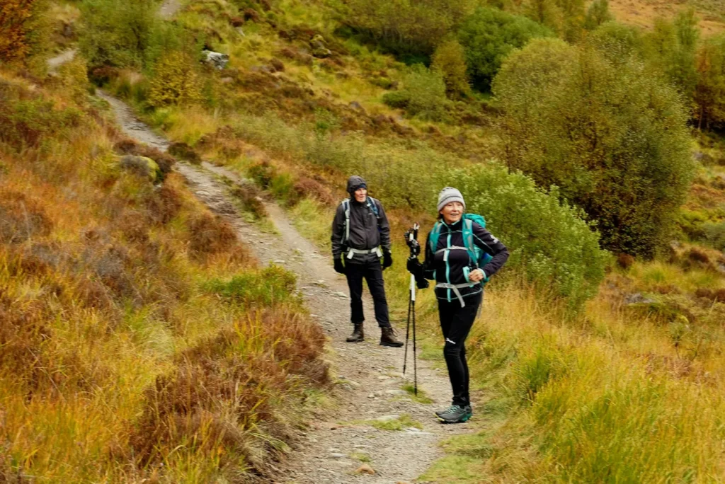 Two walkers on the Coire Ardair path in autumn